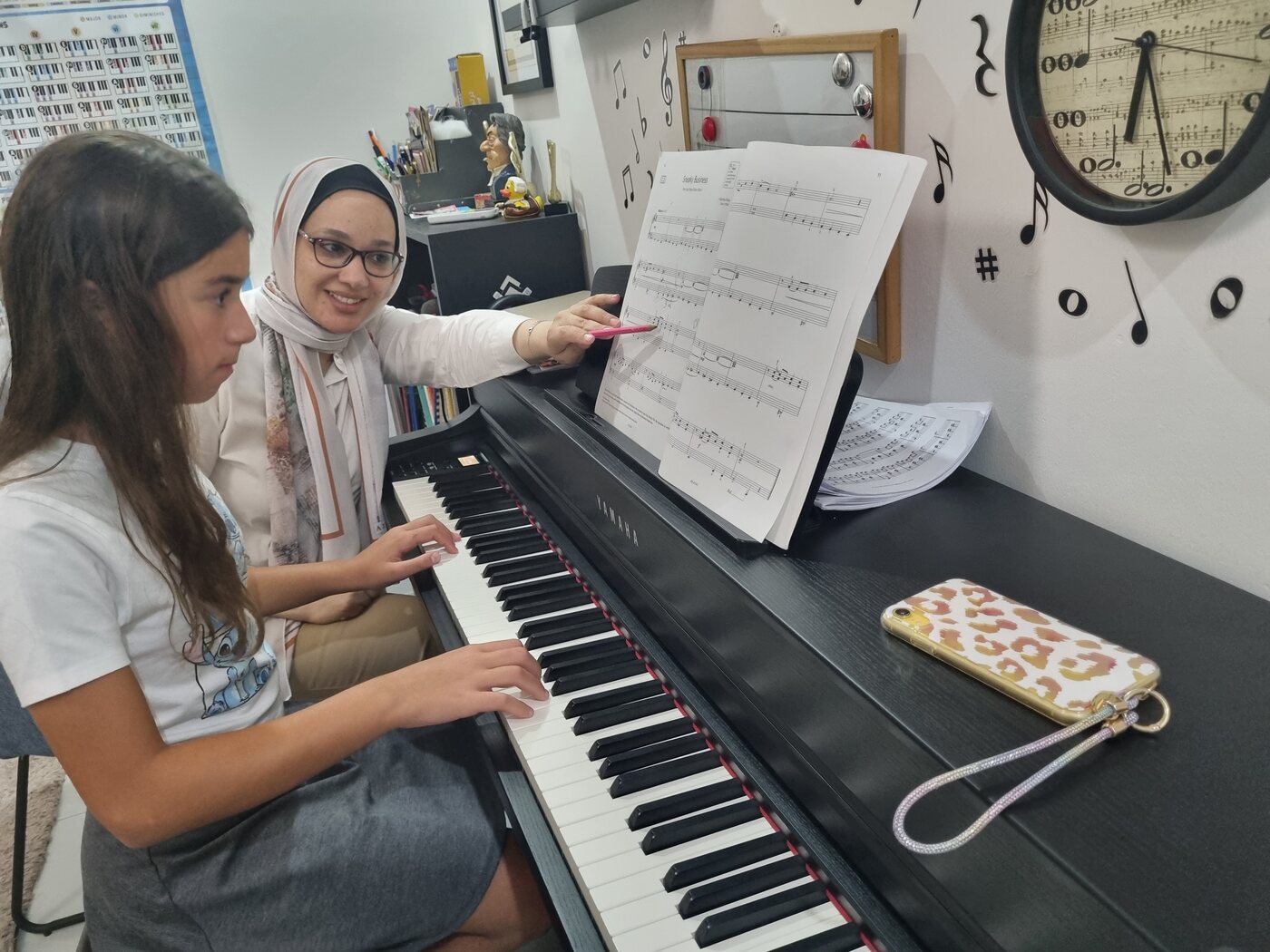 Yasmin Shennawy guiding an older student through a piece at the piano